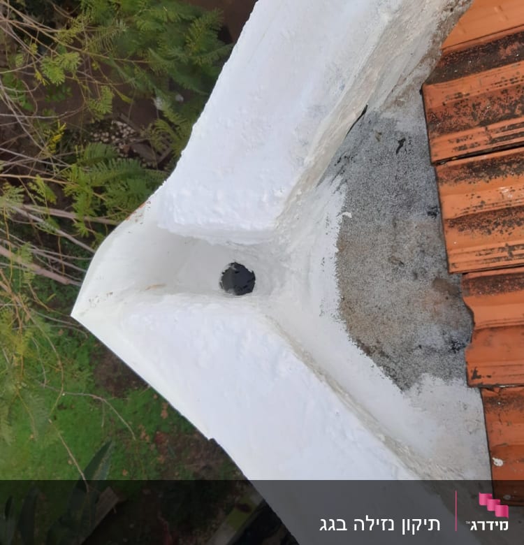 רעפים כתומים על גג עם טיח לבן